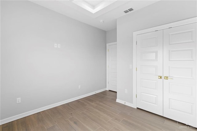 unfurnished bedroom featuring light hardwood / wood-style floors and a closet