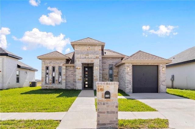 view of front of house featuring central AC, a front lawn, and a garage