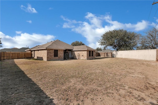 rear view of house featuring a yard