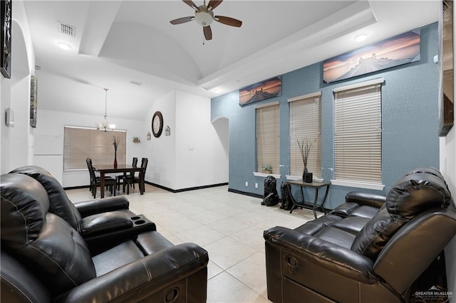 tiled living room featuring lofted ceiling and ceiling fan with notable chandelier