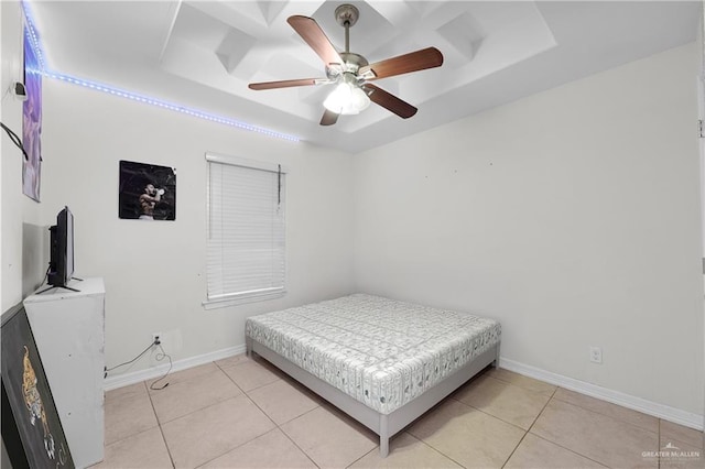 bedroom with light tile patterned flooring, ceiling fan, and a tray ceiling