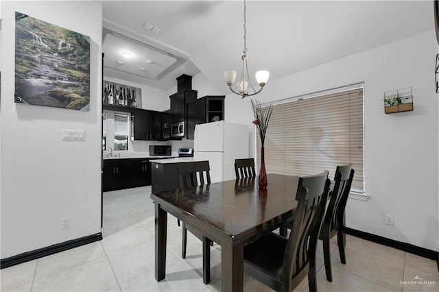 tiled dining space with sink and a chandelier