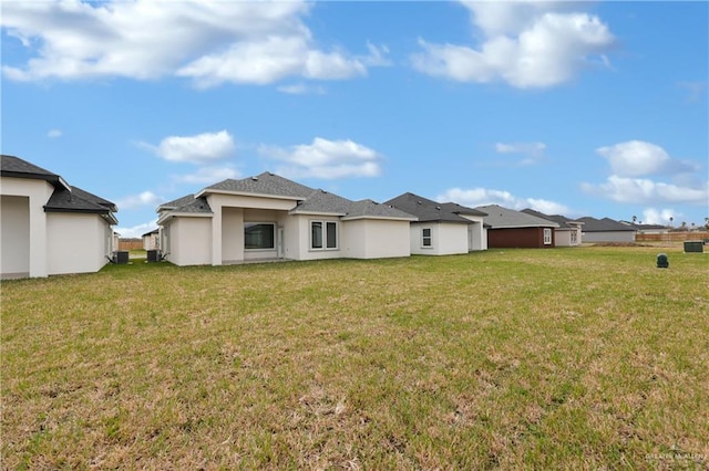 rear view of property with a yard and stucco siding