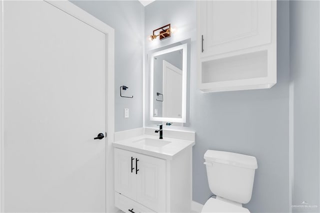 bathroom featuring toilet and vanity