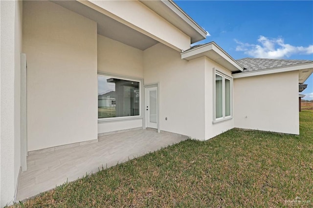 back of property with a yard and a patio