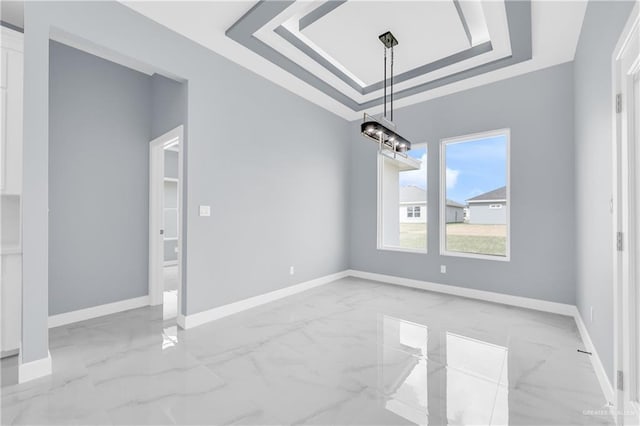 unfurnished dining area featuring a raised ceiling