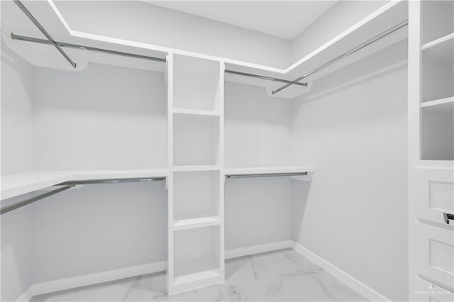 walk in closet with marble finish floor