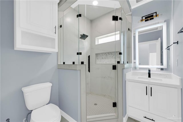 bathroom with walk in shower, vanity, and toilet