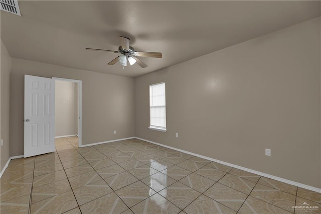 tiled spare room featuring ceiling fan