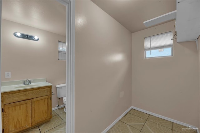 bathroom with toilet, vanity, and tile patterned floors