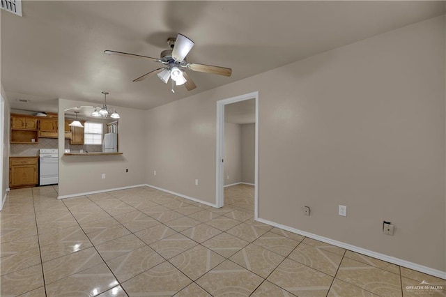 tiled empty room with ceiling fan with notable chandelier