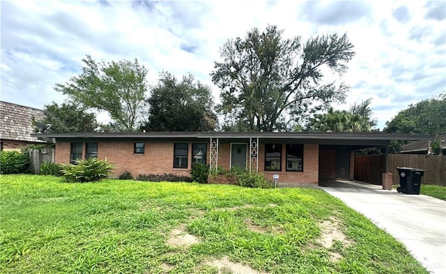 907 W 7th St, Weslaco, TX 78596 - ranch-style house with brick siding, concrete driveway, and an attached carport
