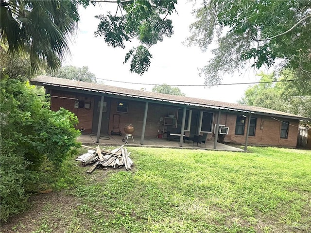 907 W 7th St, Weslaco, TX 78596 - back of property with a patio, a lawn, and brick siding