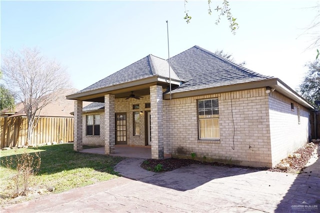 view of front of house with ceiling fan, a patio area, and a front lawn