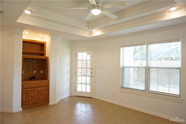 doorway to outside featuring plenty of natural light, a raised ceiling, ornamental molding, and light tile patterned floors