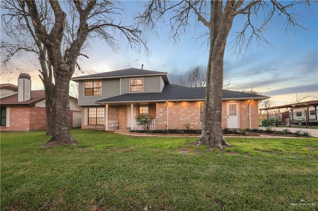 traditional-style house with a lawn and brick siding