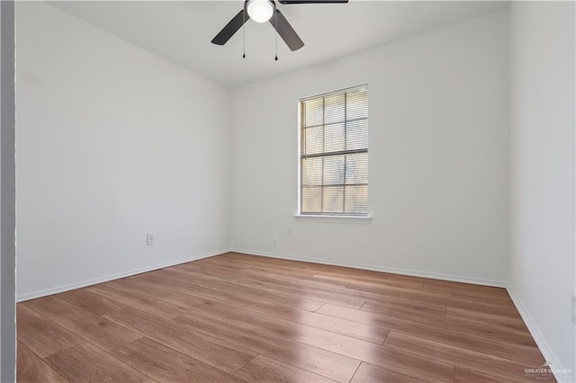 empty room with a ceiling fan, baseboards, and wood finished floors