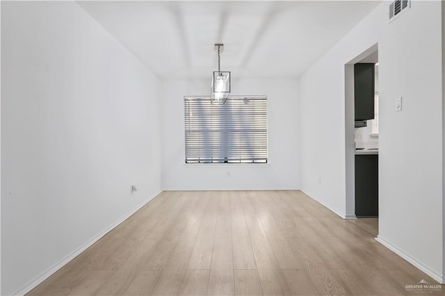 unfurnished dining area with visible vents, baseboards, and light wood finished floors