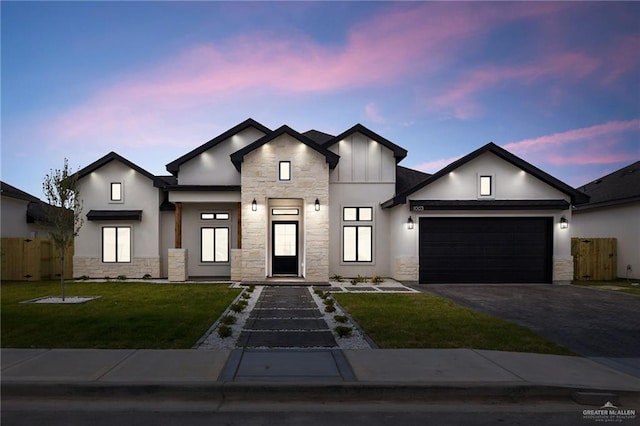 1003 Bette St, Pharr, TX 78577 - view of front facade with an attached garage, fence, stone siding, and driveway