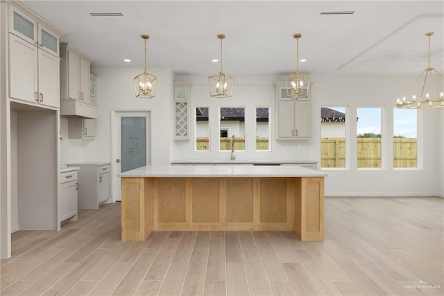 1003 Bette St, Pharr, TX 78577 - kitchen with light wood-style floors, a chandelier, a kitchen island, and recessed lighting