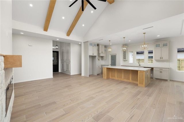 1003 Bette St, Pharr, TX 78577 - kitchen with a sink, ceiling fan with notable chandelier, light countertops, a large island, and a fireplace