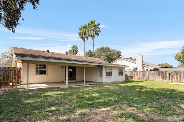 back of property featuring a yard and a patio