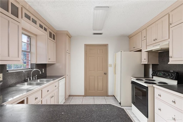 kitchen with sink, decorative backsplash, light tile patterned floors, white appliances, and a textured ceiling