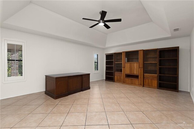 interior space featuring ceiling fan, visible vents, a raised ceiling, and light tile patterned flooring