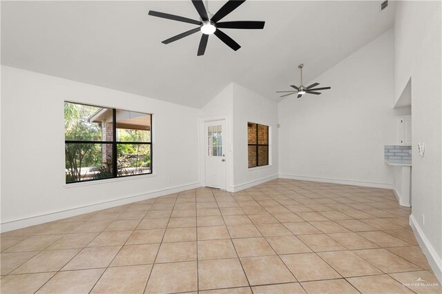 empty room featuring high vaulted ceiling, ceiling fan, and baseboards