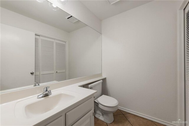 bathroom featuring tile patterned flooring, baseboards, vanity, and toilet