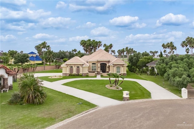 1018 Buena Suerte, Weslaco, TX 78596 - view of front facade featuring curved driveway, stucco siding, a tiled roof, and a front yard