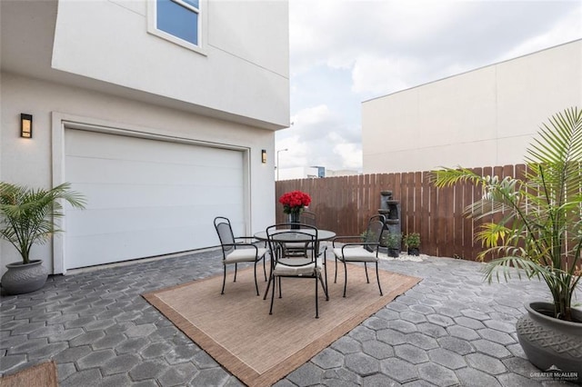 view of patio with outdoor dining space and fence
