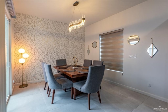 tiled dining room with an accent wall, a healthy amount of sunlight, baseboards, and wallpapered walls