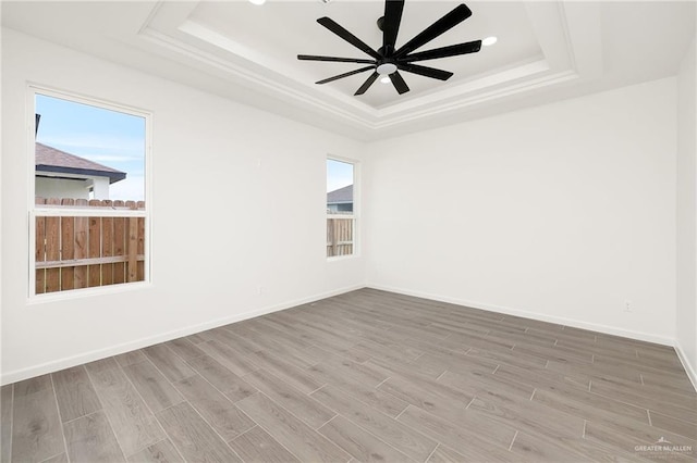 904 N Trinity St, Edinburg, TX 78541 - spare room featuring a tray ceiling, wood finished floors, ceiling fan, and healthy amount of natural light