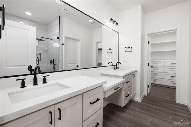904 N Trinity St, Edinburg, TX 78541 - bathroom featuring a stall shower, vanity, a walk in closet, wood finished floors, and recessed lighting