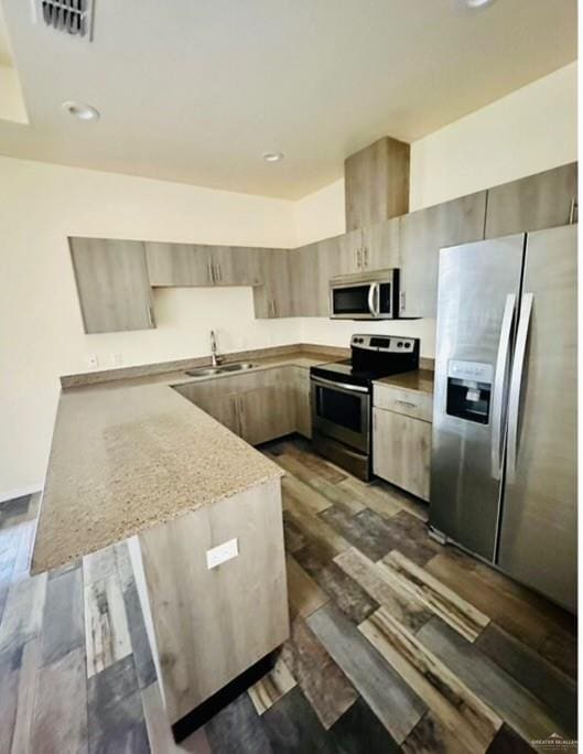 kitchen with dark wood-type flooring, sink, light brown cabinetry, light stone counters, and stainless steel appliances