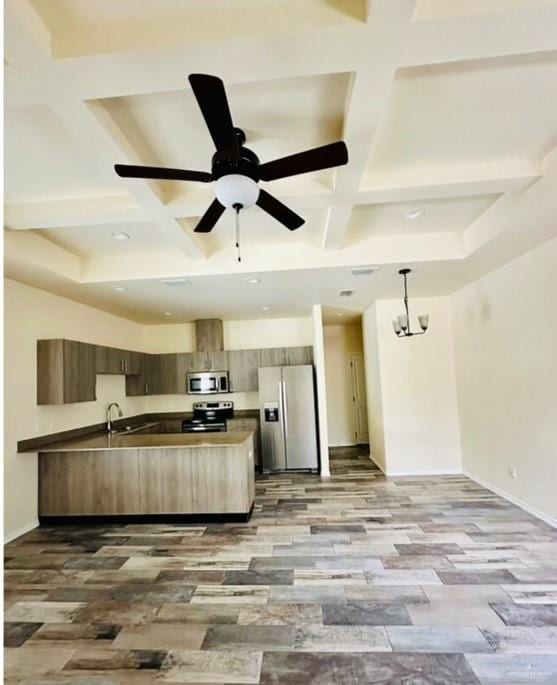 kitchen featuring beam ceiling, coffered ceiling, pendant lighting, light hardwood / wood-style floors, and appliances with stainless steel finishes