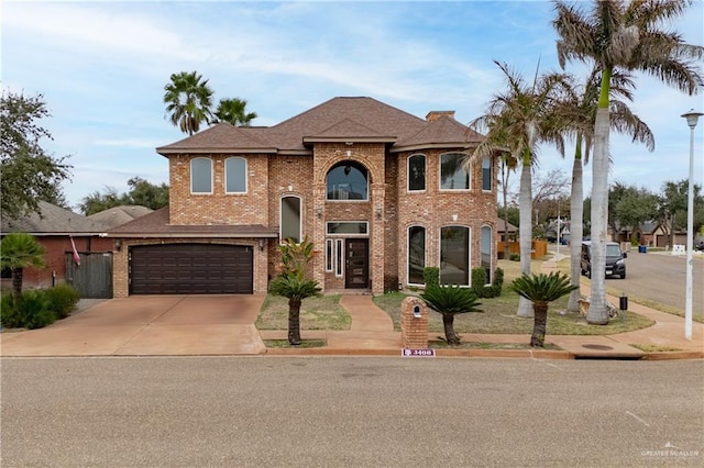 view of front of property featuring a garage, brick siding, driveway, and roof with shingles