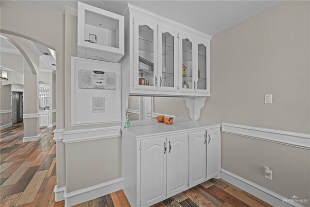 bar featuring white cabinets and dark hardwood / wood-style flooring