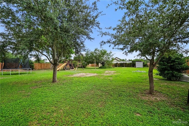 view of yard featuring a playground and a trampoline