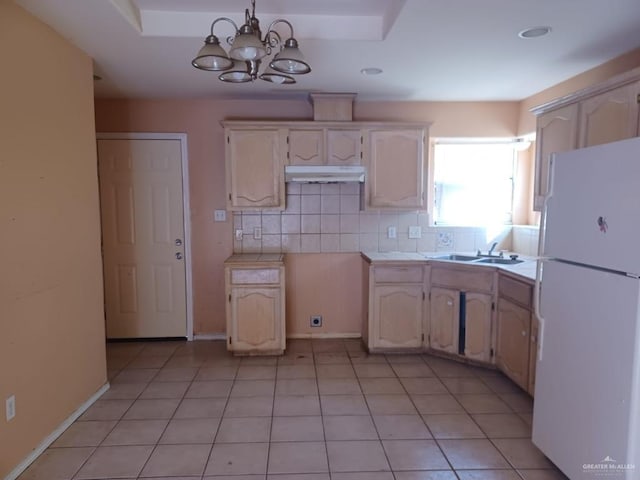 kitchen featuring backsplash, white refrigerator, a notable chandelier, hanging light fixtures, and light tile patterned flooring