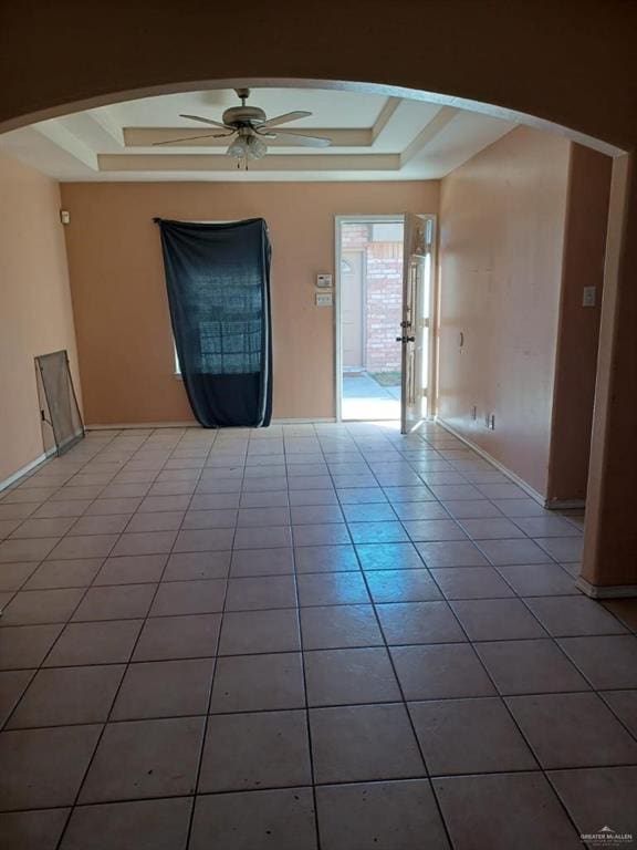 spare room featuring tile patterned flooring, ceiling fan, and a tray ceiling