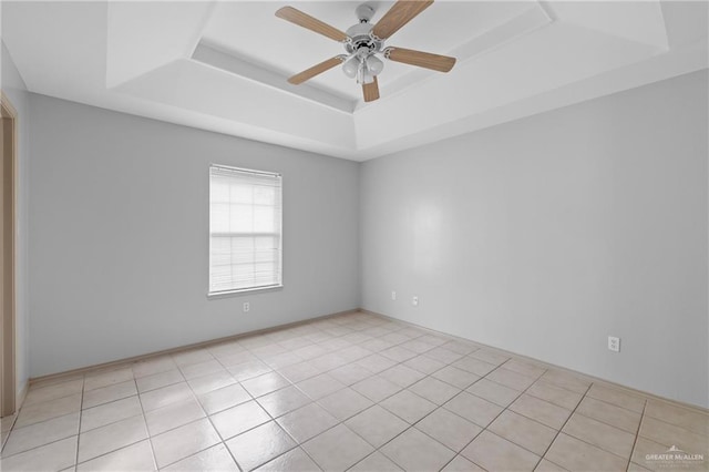 unfurnished room featuring light tile patterned floors, a raised ceiling, and ceiling fan