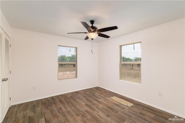 spare room with ceiling fan, plenty of natural light, and dark hardwood / wood-style flooring