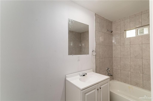 bathroom featuring tiled shower / bath and vanity