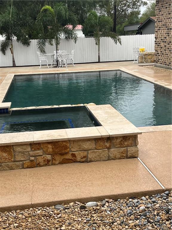 view of pool featuring a patio area and an in ground hot tub