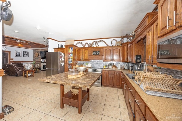 kitchen with backsplash, ornamental molding, stainless steel appliances, sink, and light tile patterned floors