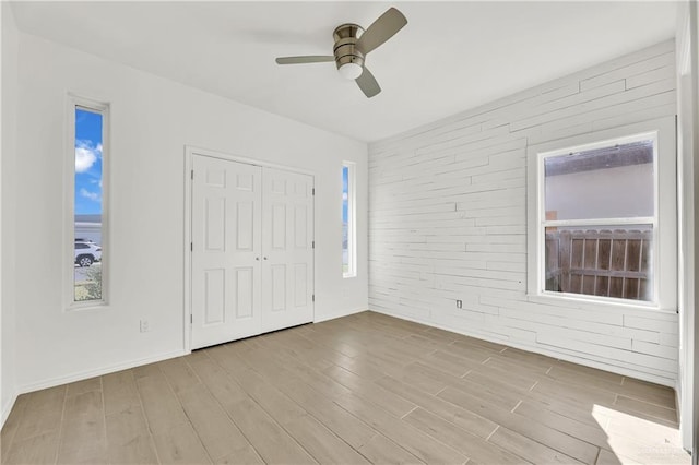 2208 Providence Ave, Mcallen, TX 78504 - unfurnished bedroom featuring brick wall, light wood-style floors, a closet, and a ceiling fan