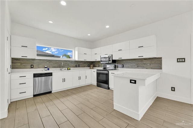 2208 Providence Ave, Mcallen, TX 78504 - kitchen with appliances with stainless steel finishes, a peninsula, backsplash, light countertops, and recessed lighting
