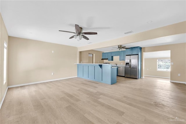 209 E 11th St, San Juan, TX 78589 - kitchen featuring appliances with stainless steel finishes, a breakfast bar, a ceiling fan, a peninsula, and baseboards